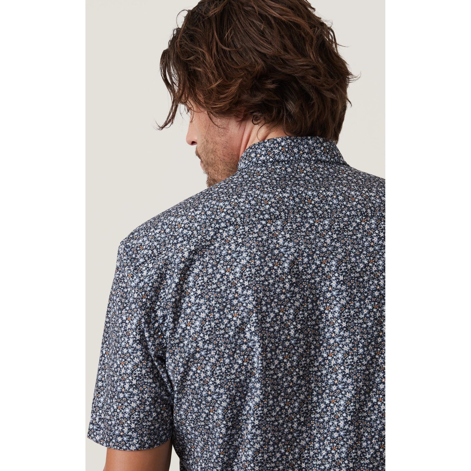 Stylish model showcasing the 34 Heritage Field Short Sleeve Shirt with a playful floral pattern, perfect for summer.