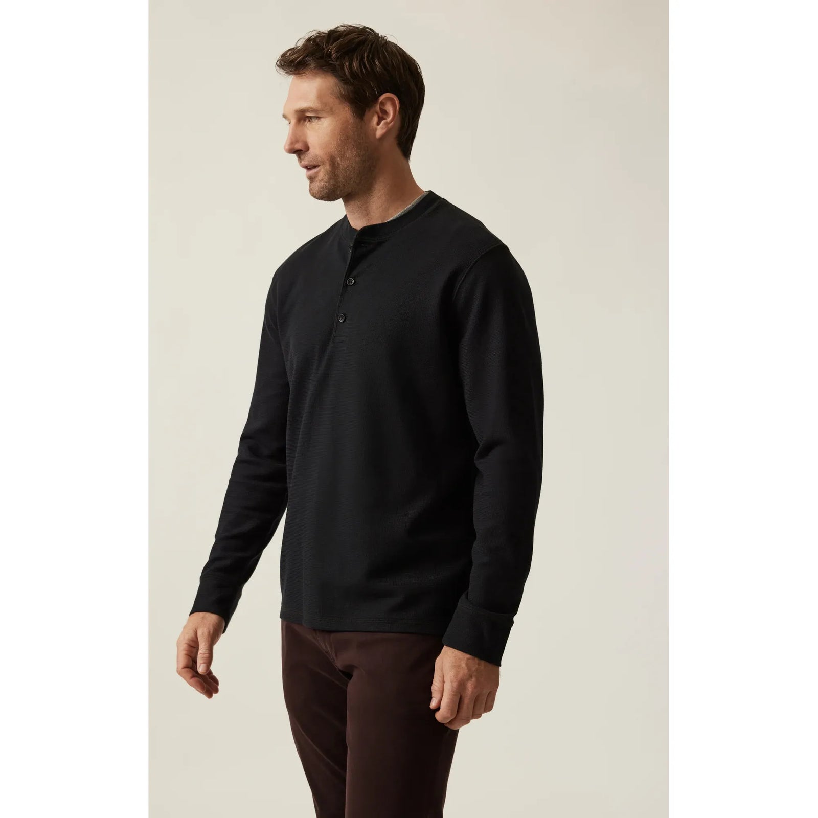 34 Heritage Long Sleeve Henley in jet black on a man, featuring a 3-button placket and soft Pima cotton-spandex blend.
