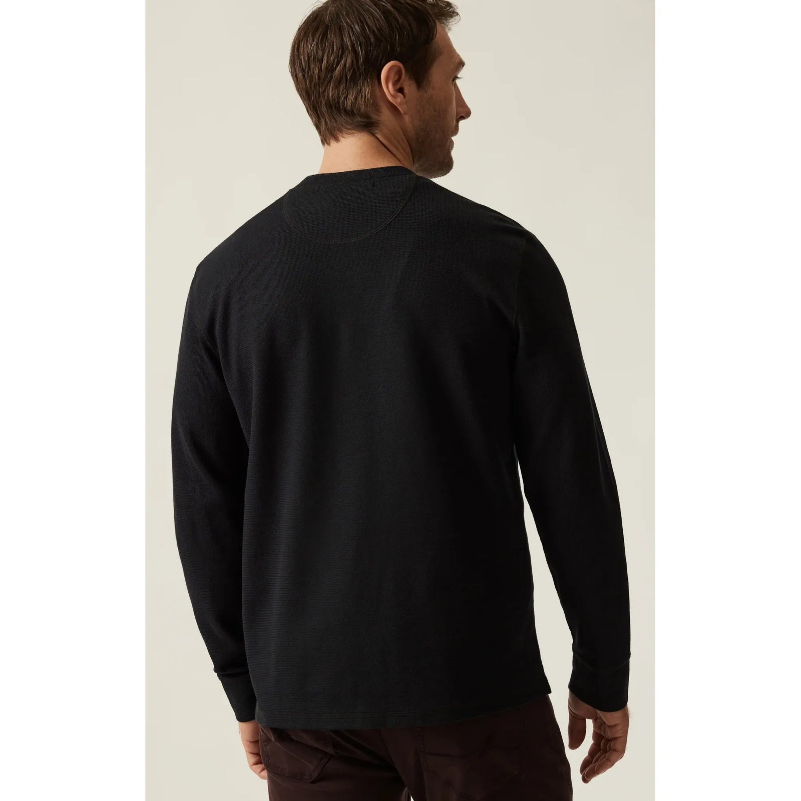 Back view of a man wearing the 34 Heritage Long Sleeve Henley in jet black, soft Pima cotton-spandex blend.