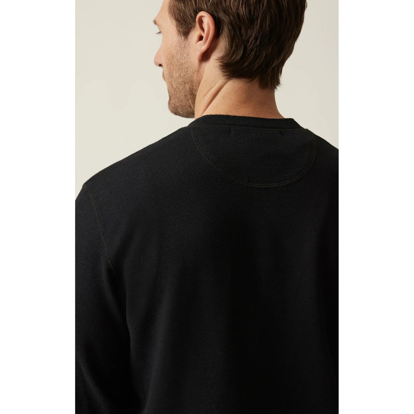 Back view of a man wearing a jet-black 34 Heritage Long Sleeve Henley, a soft Pima cotton-spandex knit.