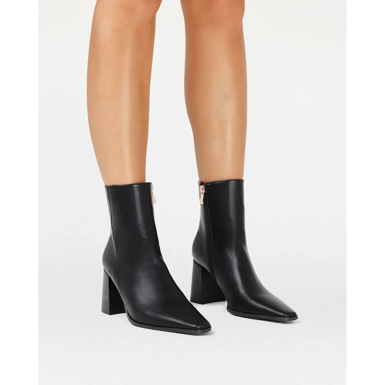 Black Billini Ozi Boot with a closed square toe, mid-flare block heel, and gold zip detail on the side.