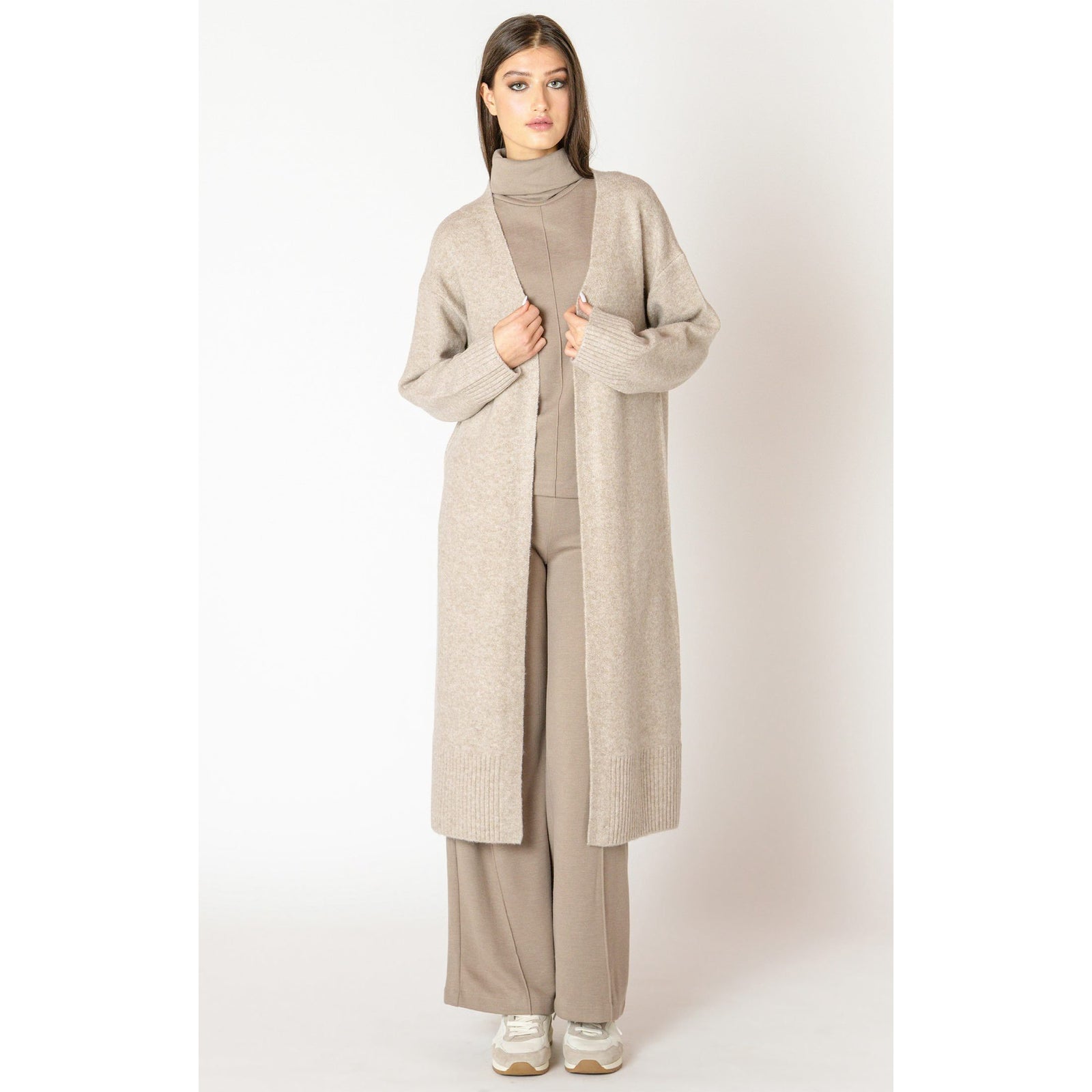 Dex Black Tape Longline open cardigan worn open over taupe turtleneck and wide-leg pants.