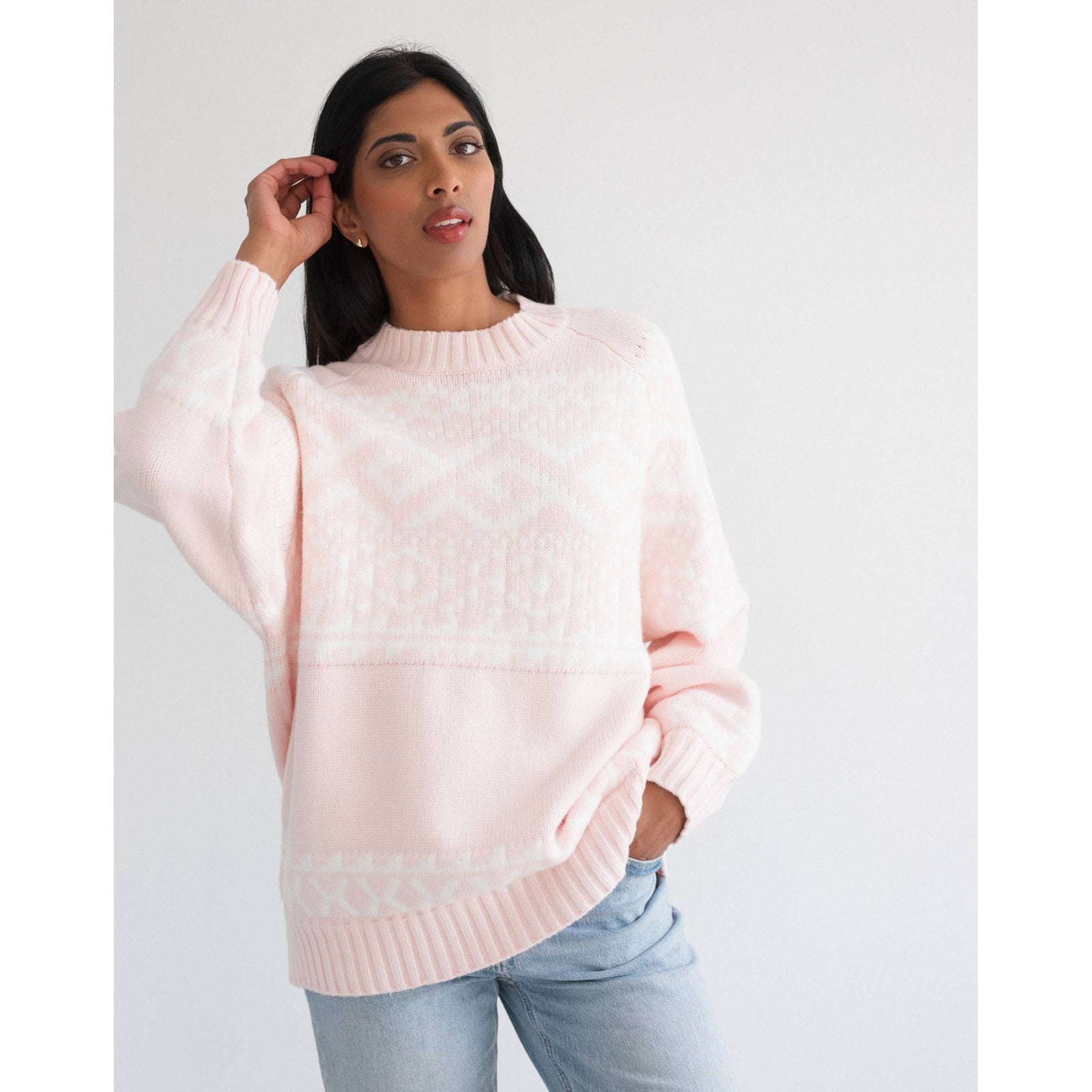 Model wearing Brunette the Label Fair Isle sweater in pale pink, oversized knit with drop shoulders.