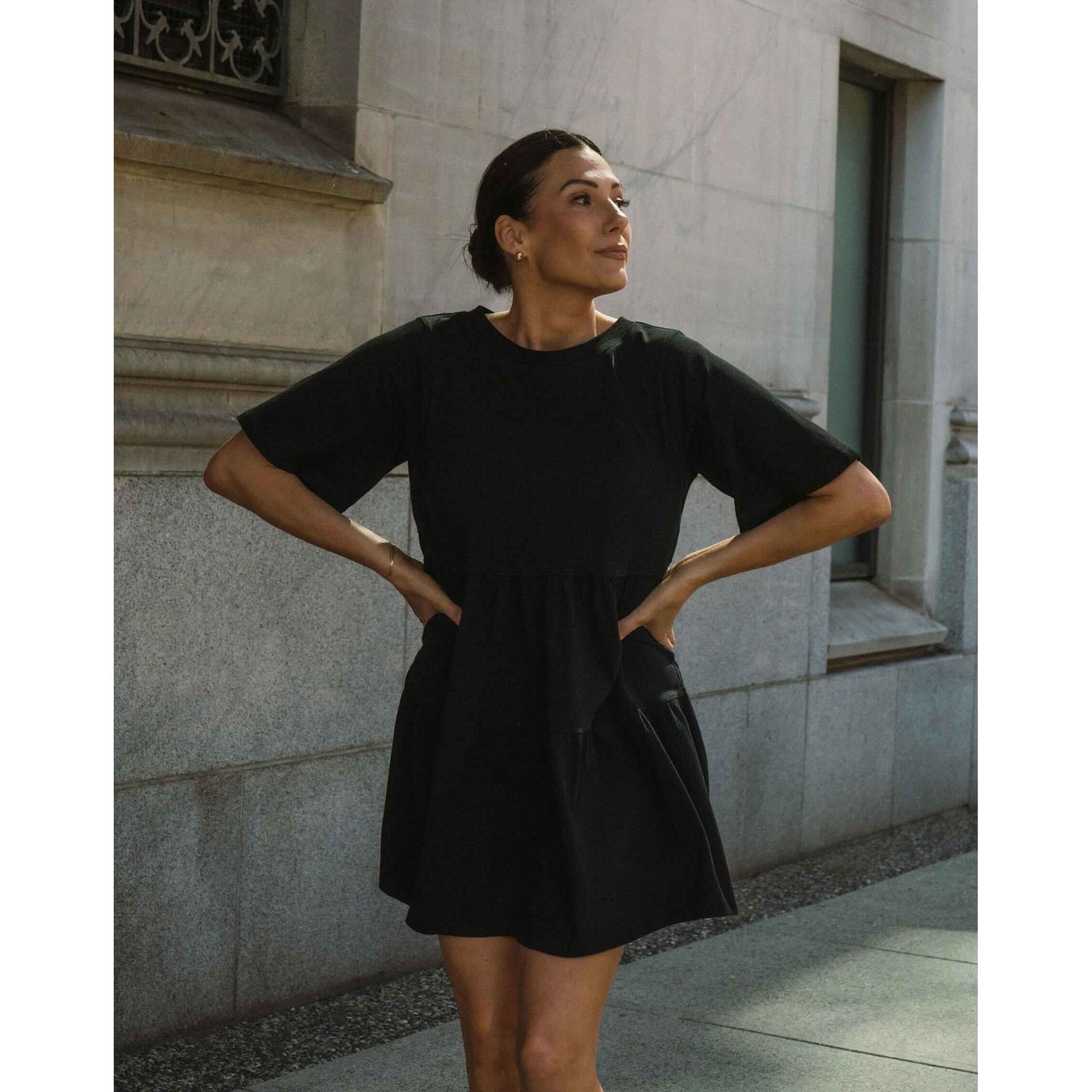 Brunette The Label Tiered Dress worn by a woman in a black oversized short-sleeve dress outdoors.