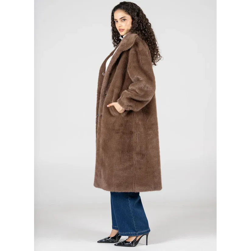 C'est Moi faux-fur long coat with lapel collar, snap buttons, and side pockets worn by a model.