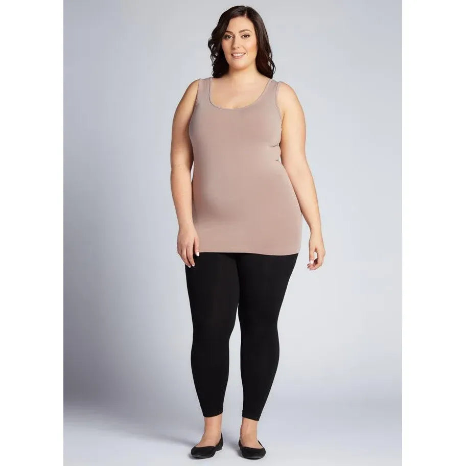 Woman wearing black fleece lined bamboo leggings and a taupe tank top, showcasing warm and comfortable plus-size leg wear.