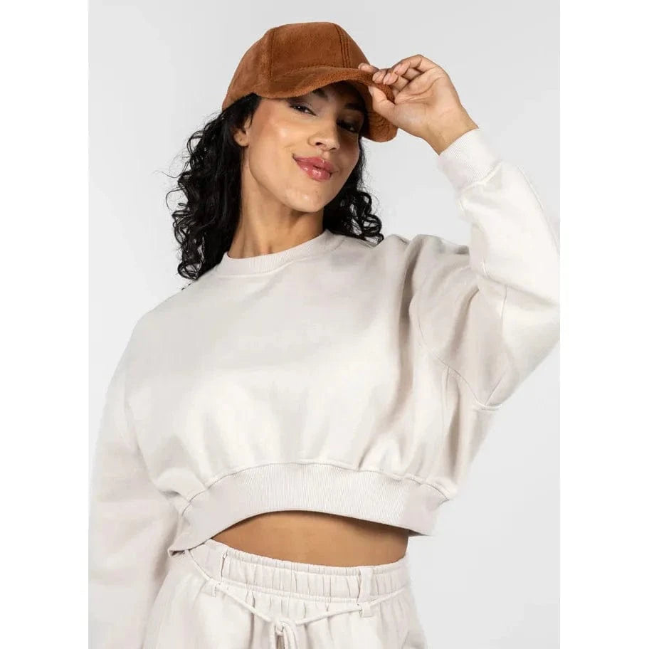 C'est Moi plush baseball hat in tan worn by a model with a white cropped sweatshirt.