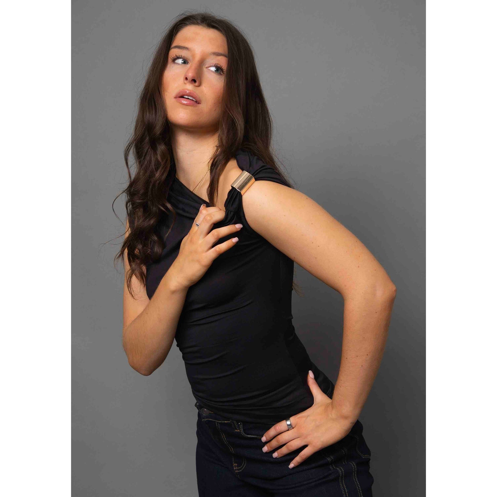 Damian Asymmetric Top on a model: black sleeveless one-shoulder top with gold hardware, versatile from casual to chic.