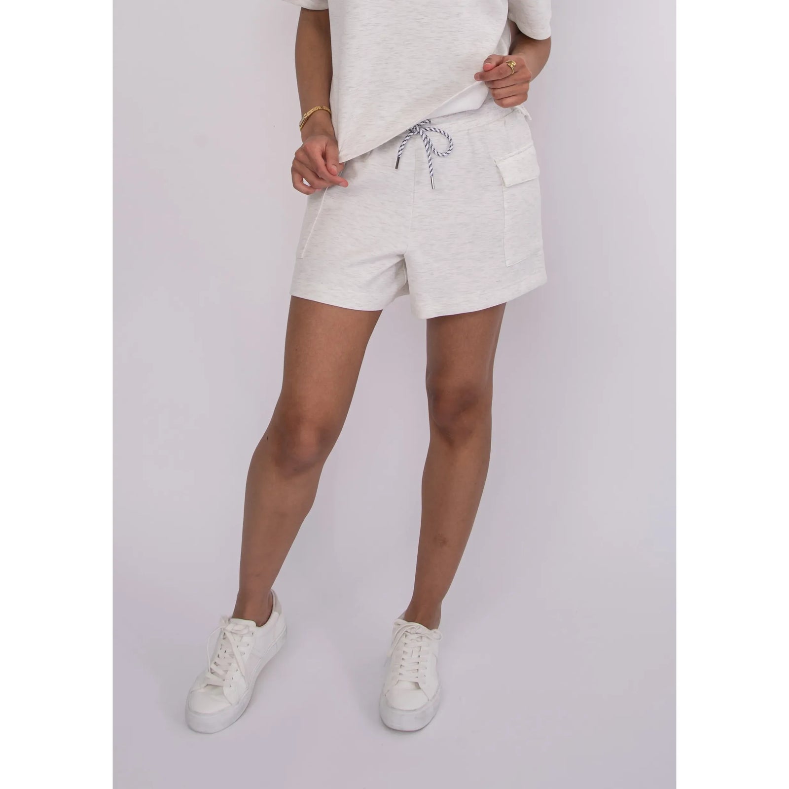 Darcia Soft Knit Drawstring Shorts in heathered ivory melange with pockets and a drawstring, styled with a casual top.