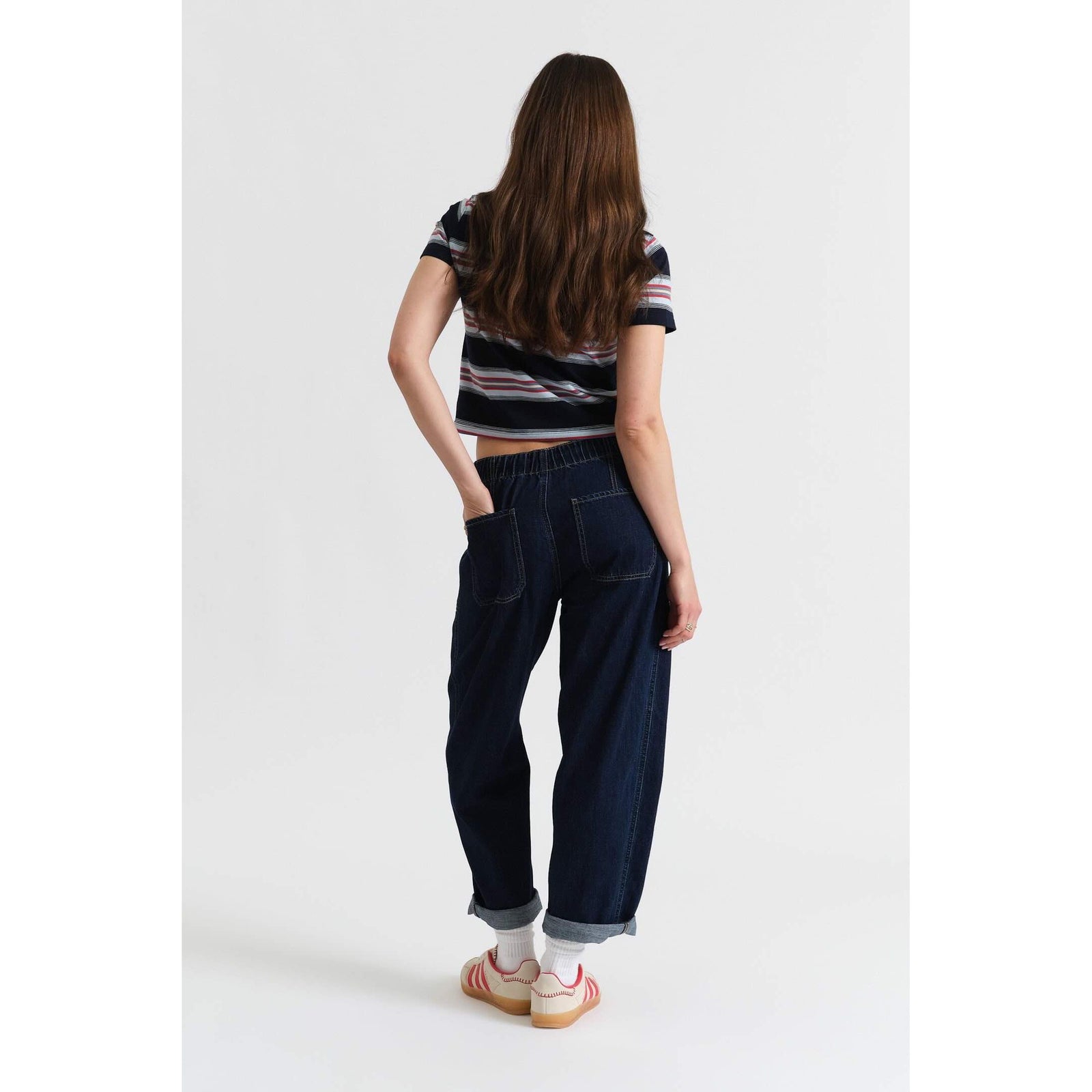 Back view of a model wearing Daze Villa Drawstring Barrel pants in Blue Mood with a drawstring waist and cuffed ankles.