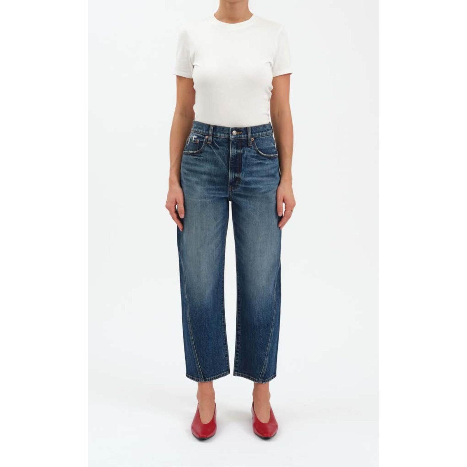 High-rise dark indigo barrel leg jeans with a cinched waist, structural bowed leg, and slightly tapered ankle.
