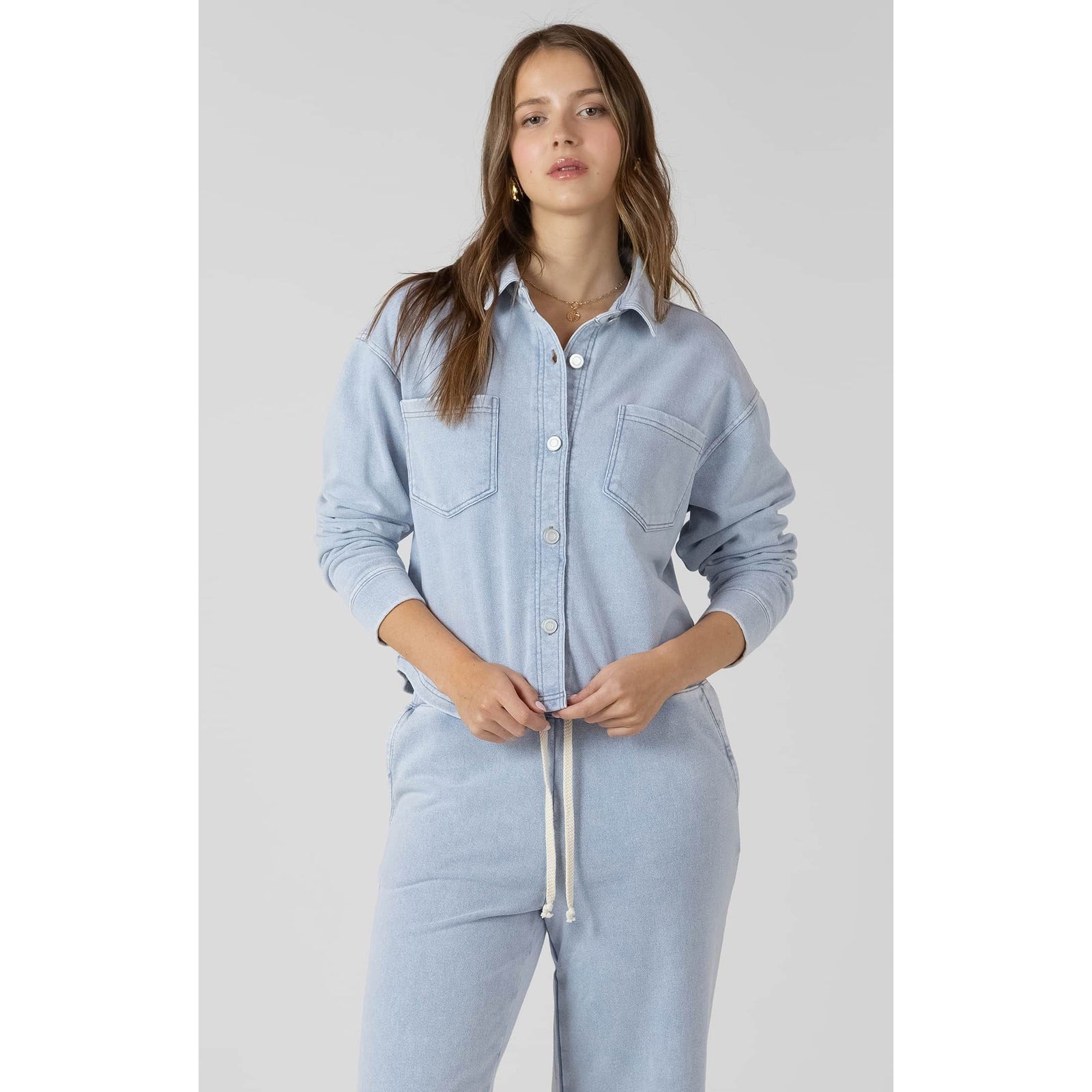 Model wearing light-wash Dex Cropped Knit Overshirt with front pockets and button-front closure.