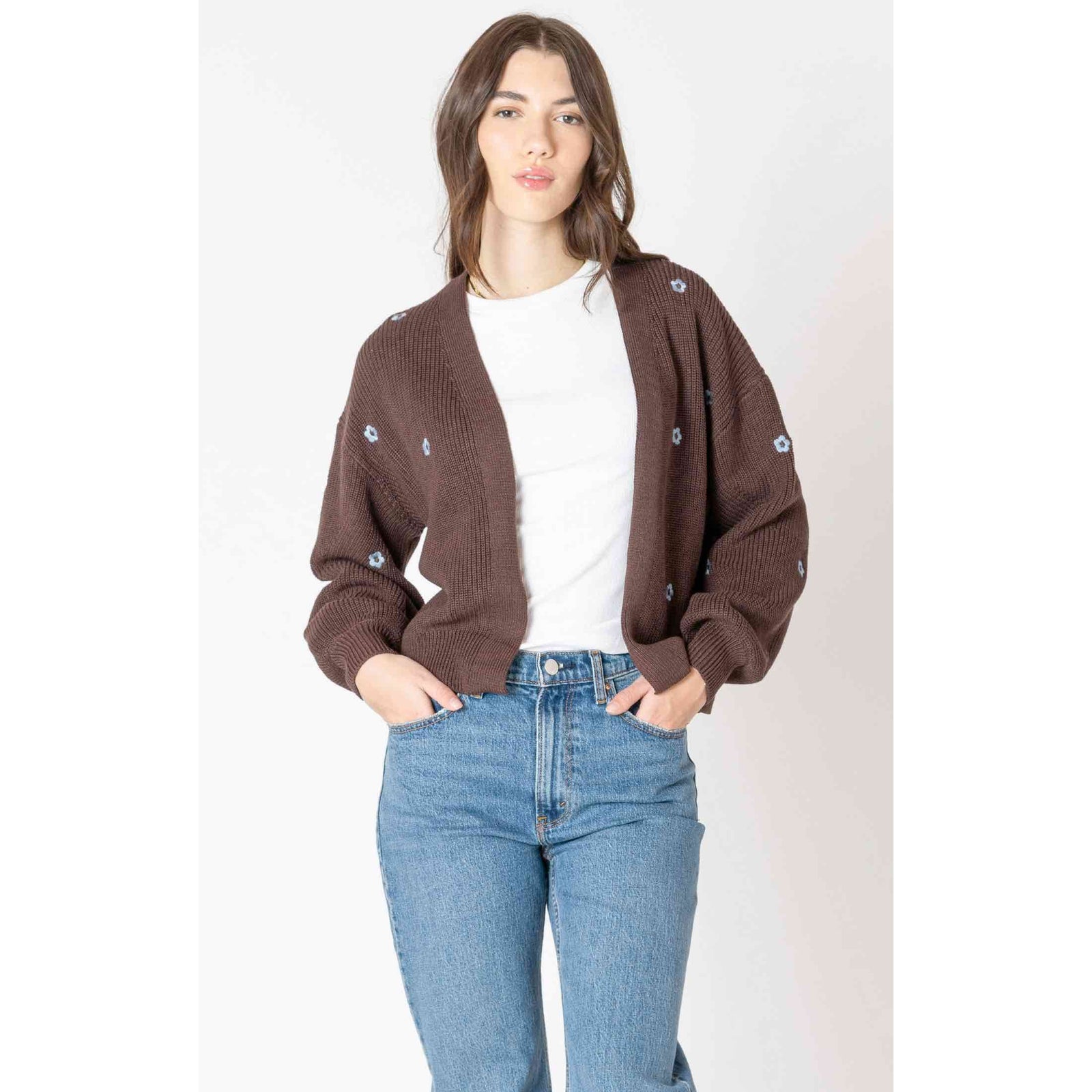 Dex Embroidered Open Cardigan in brown with blue floral embroidery, open-front, layered over white tee and jeans.