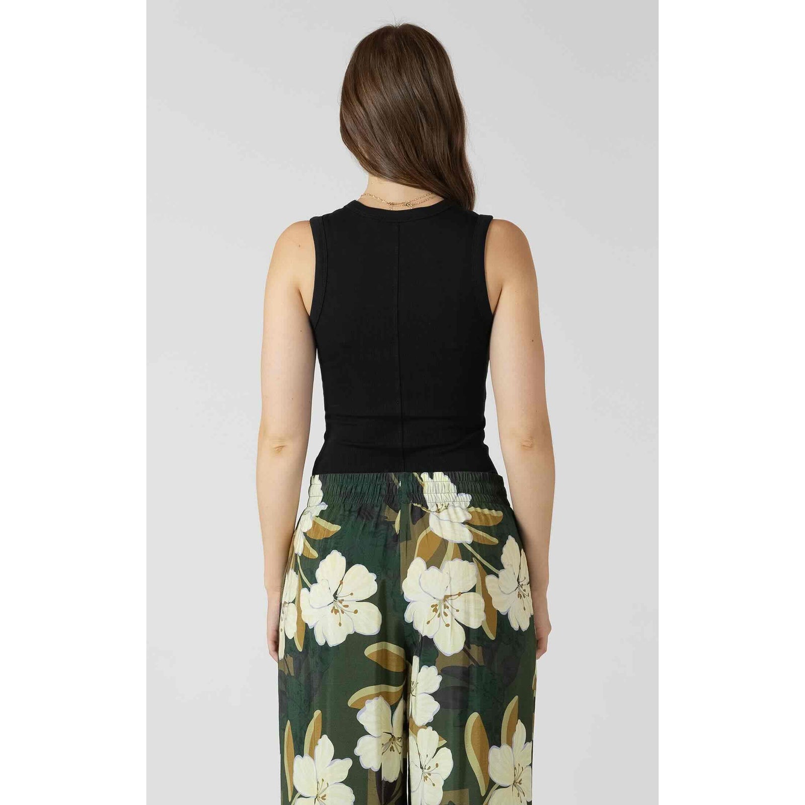 Back view of Dex Ribbed Tank in ribbed fabric worn with green floral pants.