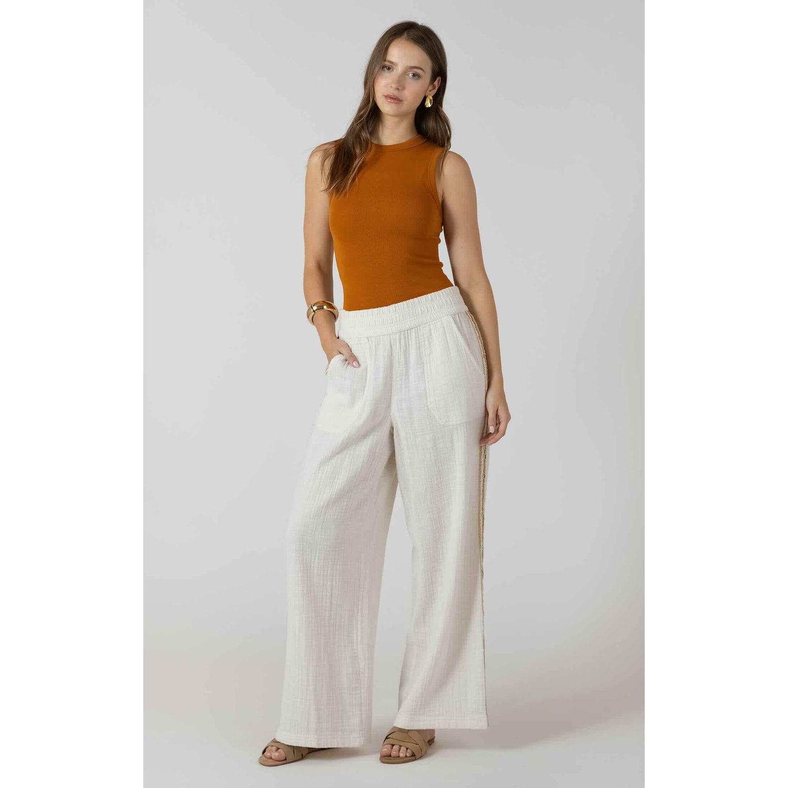 Dex Ribbed Tank in rust color paired with white wide-leg pants on model.