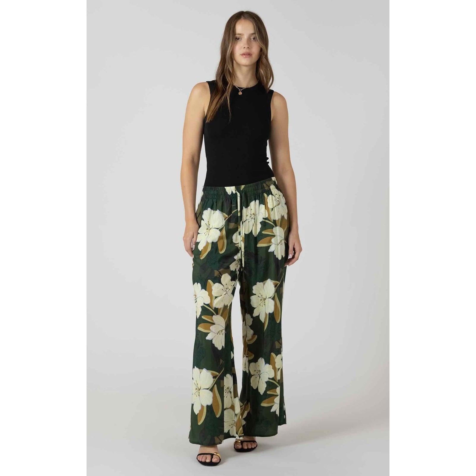 Dex Wide Leg Flowy Pants in green floral print with a relaxed, draped silhouette, paired with a black sleeveless top.