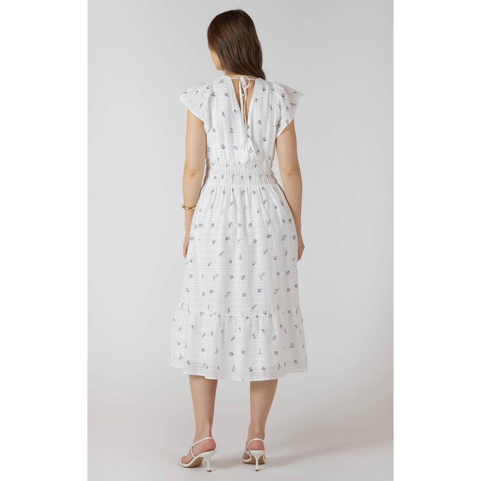 Back view of a white floral Dex Wrap Front Tiered Midi Dress with flutter sleeves and smocked waist.