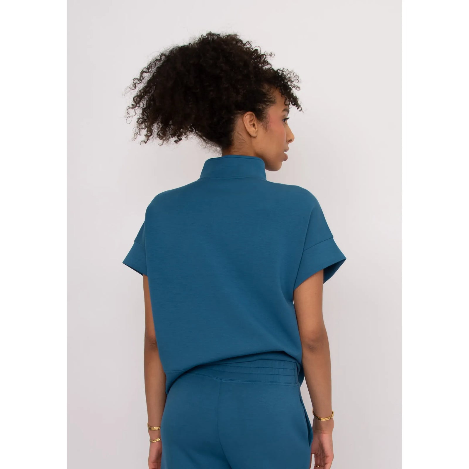 Dua Soft Knit 1/2 Zip Top in teal, back view with short cuffed sleeves and a relaxed breezy fit.