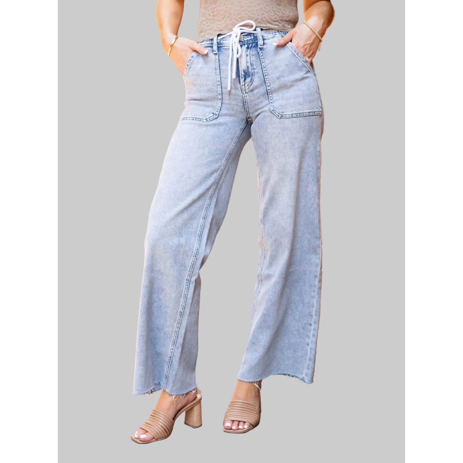 Flying Monkey Clearly High Rise Drawstring Wide Leg jeans in light wash with frayed hems, paired with tan sandals.