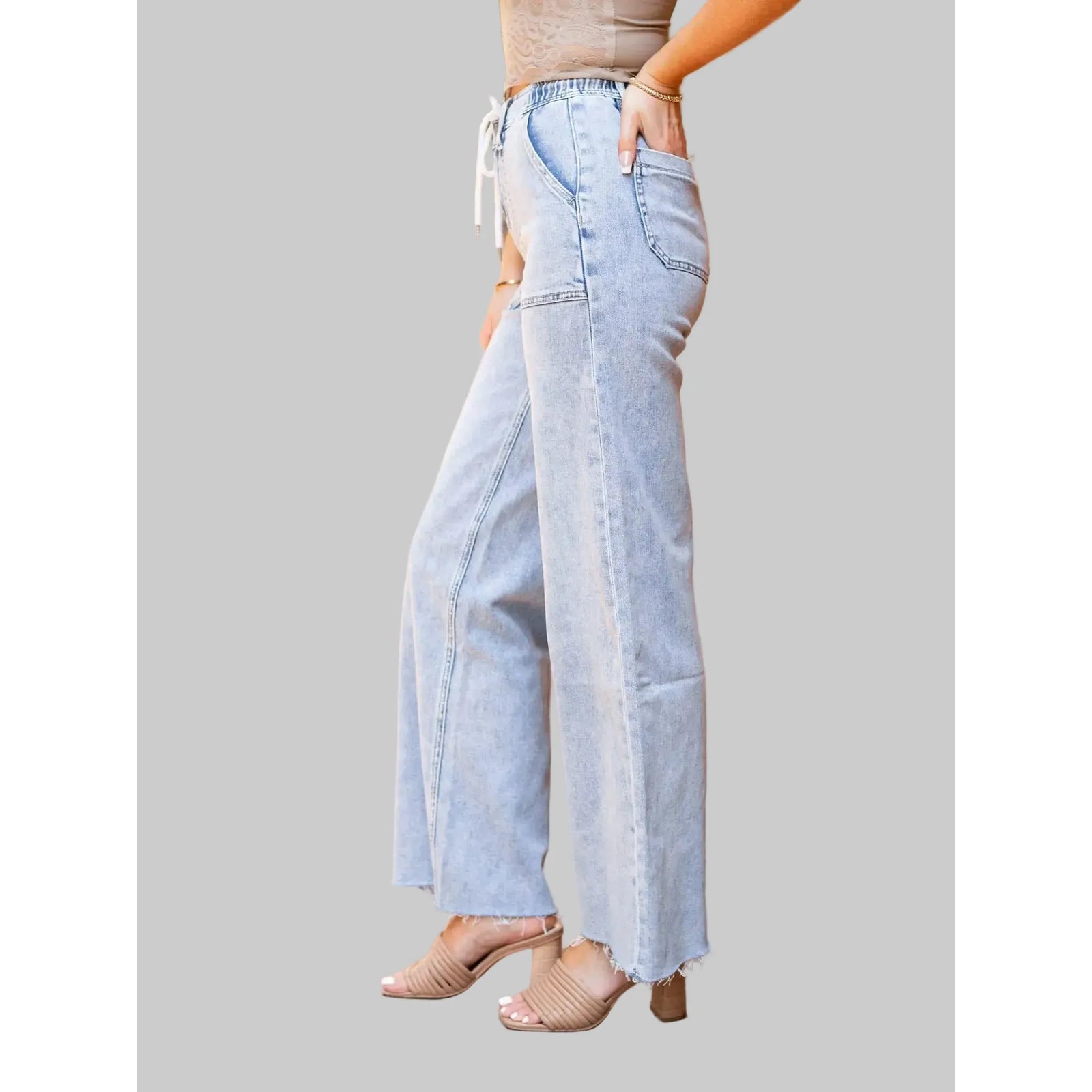 Flying Monkey Clearly High Rise Drawstring Wide Leg jeans in light wash denim with frayed hems and patch pockets.