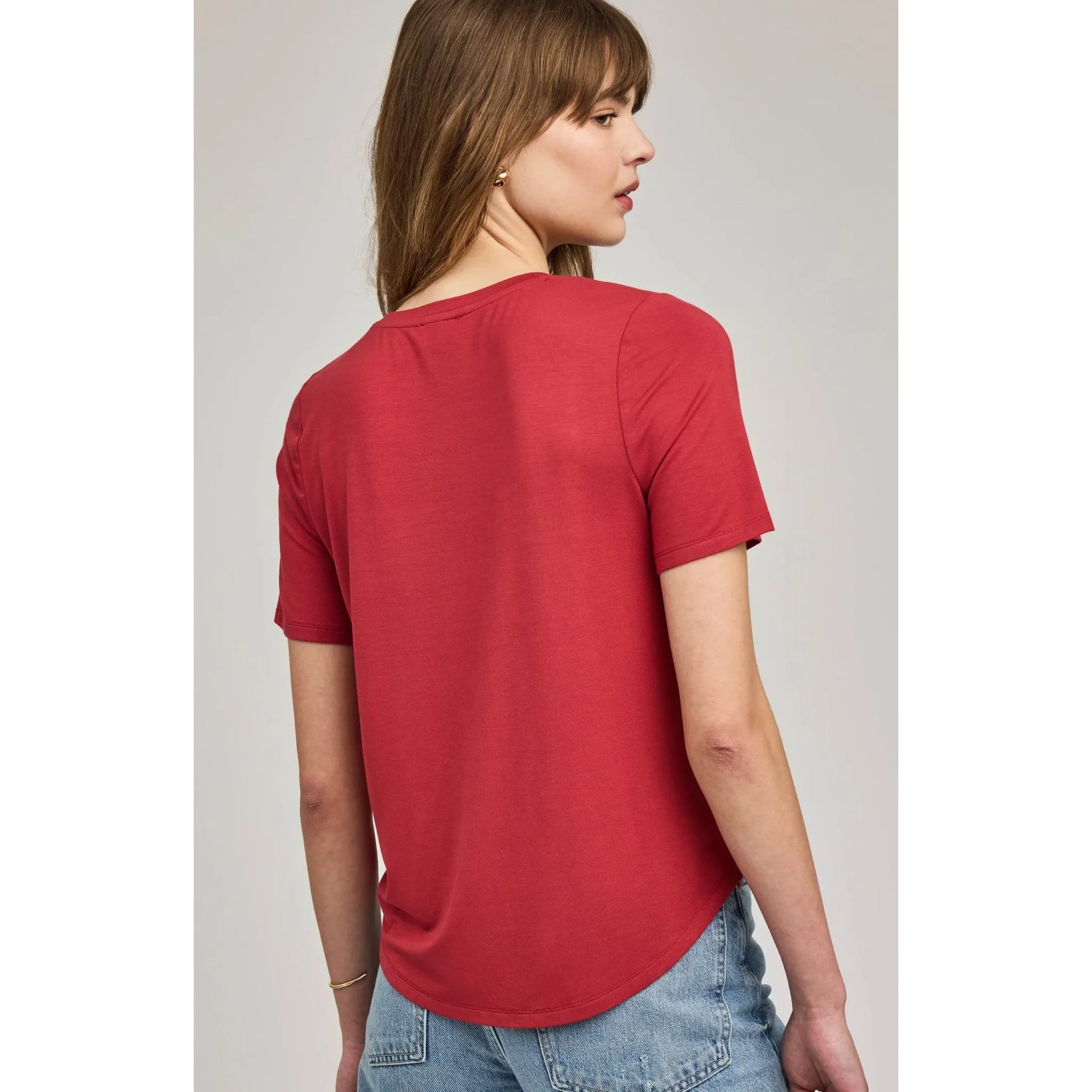 Back view of red Brielle TShirt on model, relaxed fit with curved hem, paired with jeans.