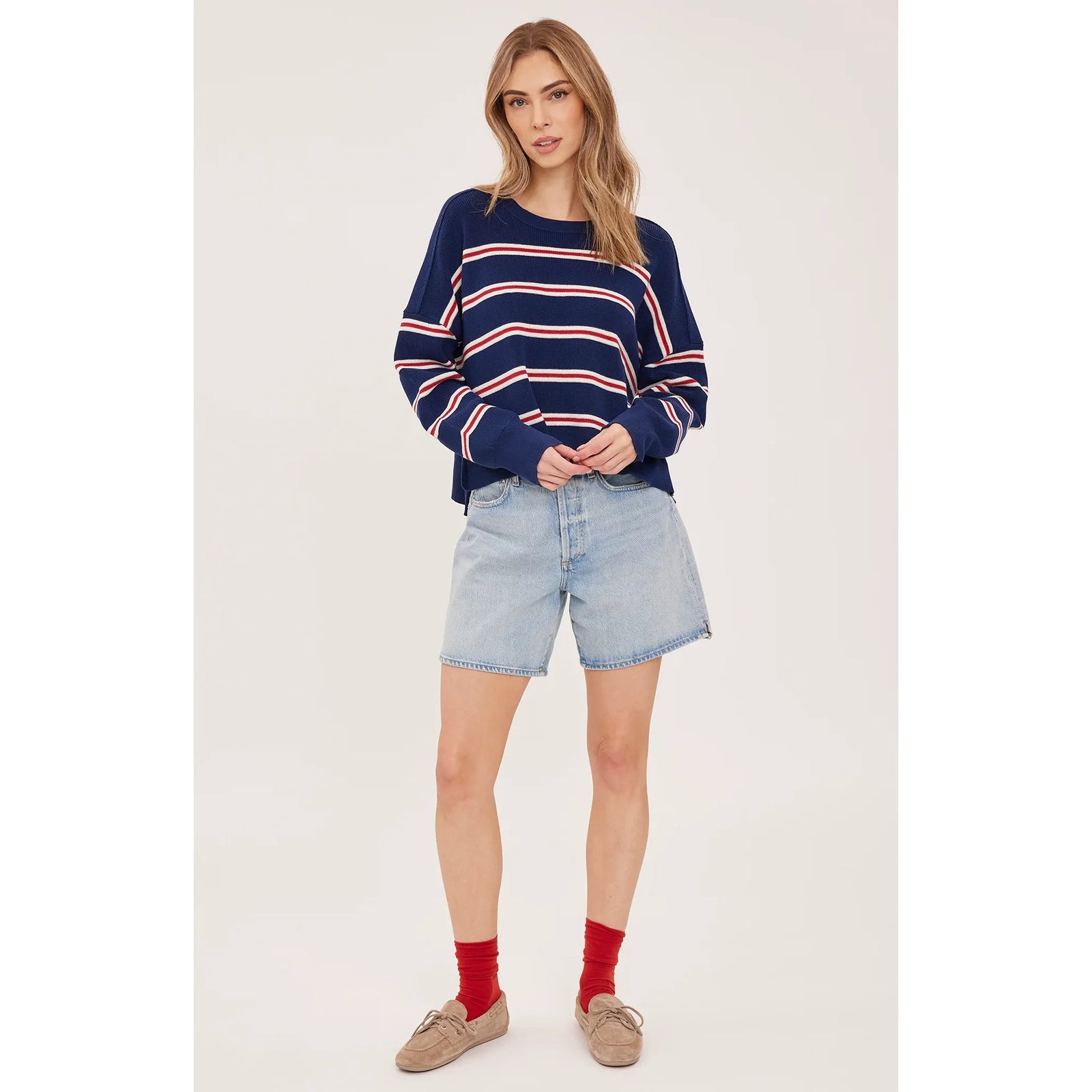 Oversized navy stripe sweater with red and white horizontal bands, featuring a crew neck, long sleeves, and side slits, styled with denim shorts.