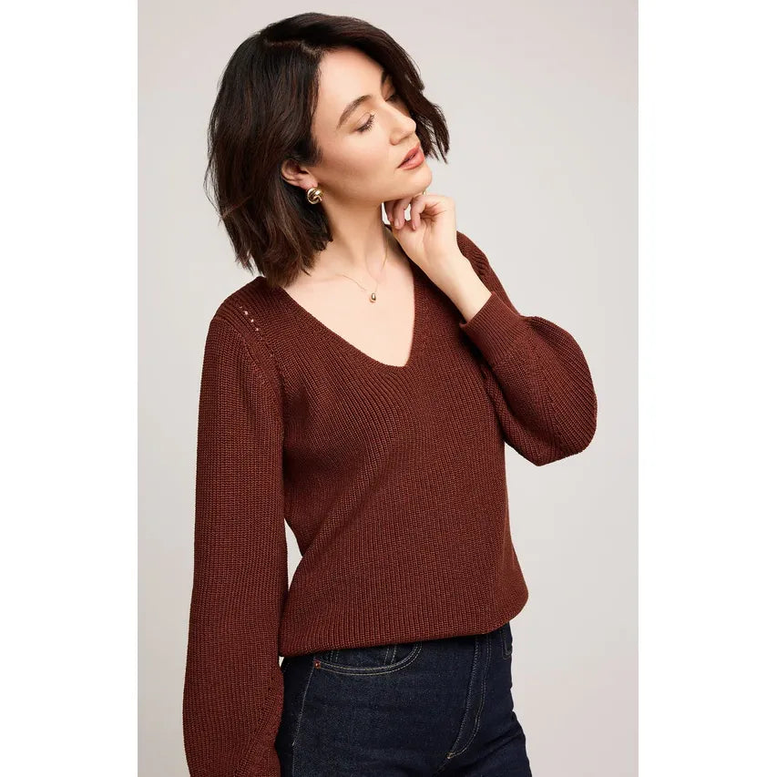 Woman wearing burgundy Gentle Fawn Hailey Pullover Sweater with V-neck and balloon sleeves.