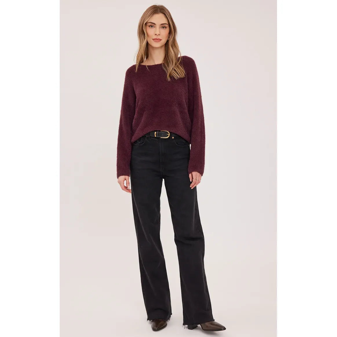 Plush deep Port Mara sweater with boat neckline and dolman sleeves, styled with dark denim and boots for a relaxed fall look.