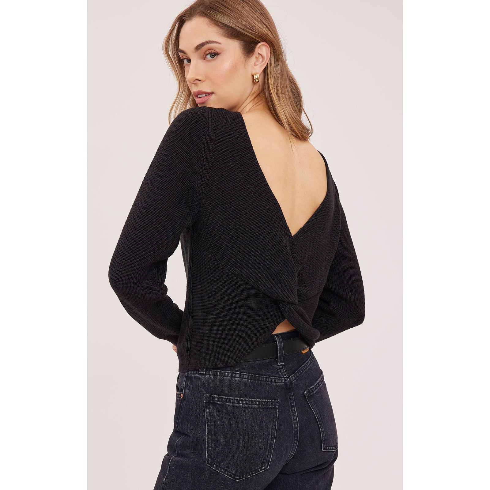 Back view of a black slim-fit pullover sweater with a twisted half-cardigan-stitch detail and open V-back neckline.