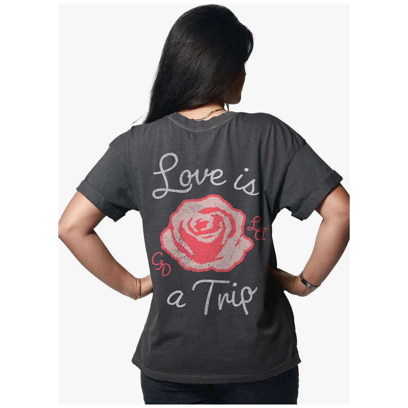Stylish model showcasing the Girl Dangerous Love is a Trip Vintage Tee, featuring a relaxed fit and vibrant rose graphic.