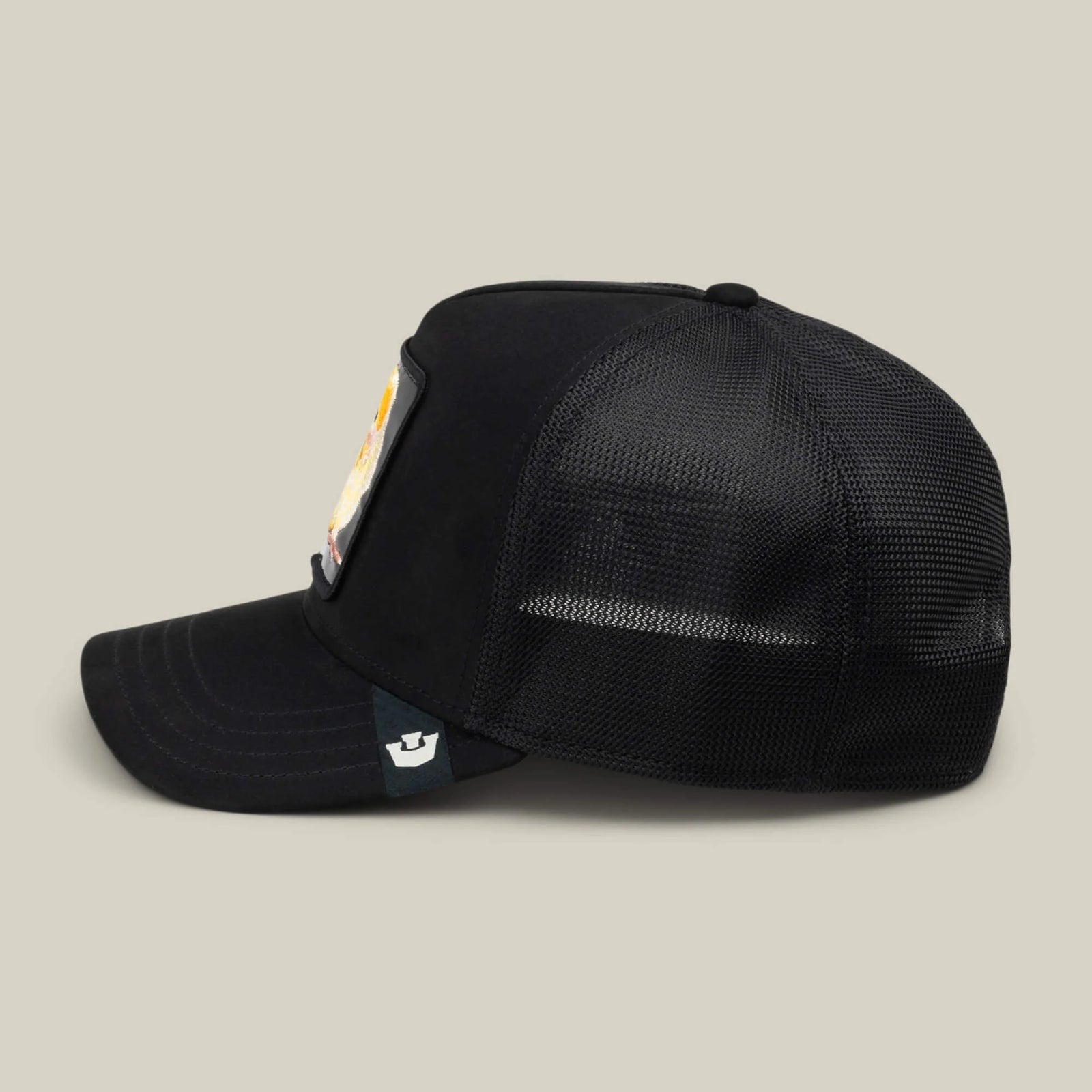 Goorin Bros Black Out Chick Trucker Hat side view. All-black mesh design with colorful chick patch from The Animal Farm series and white logo tag on brim.