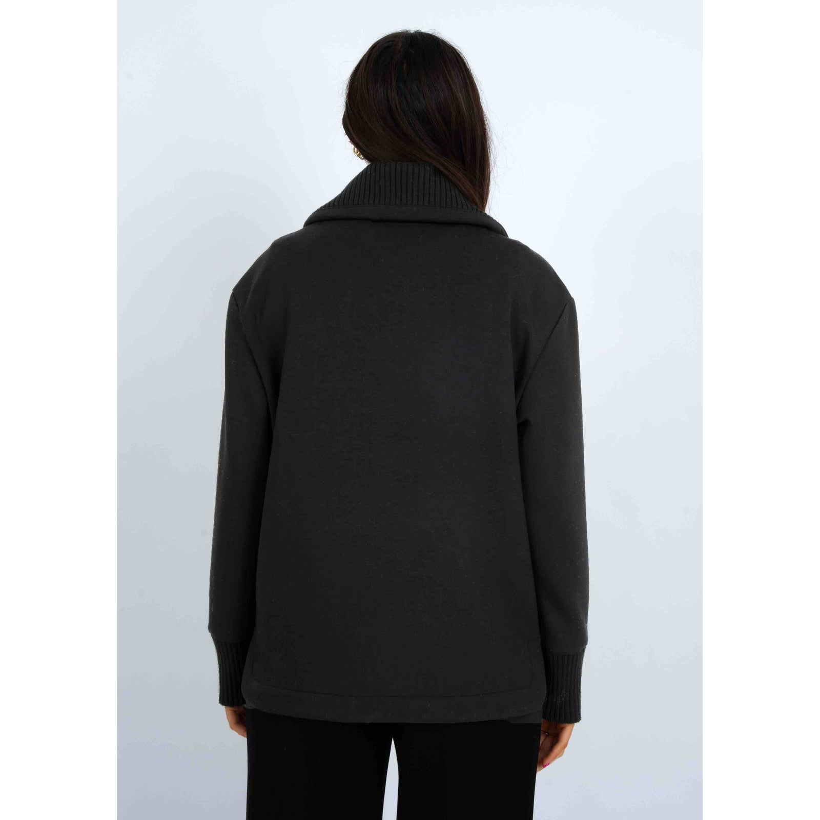 Back view of a model wearing a black Judia Soft Knit Zip Sweater in an oversized fit with a ribbed collar and cuffs.