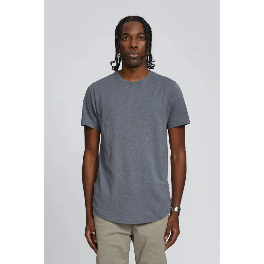 Kuwalla Scoop Tee in stone grey on model; lightweight, slim fit with scooped hems front and back, branded label.
