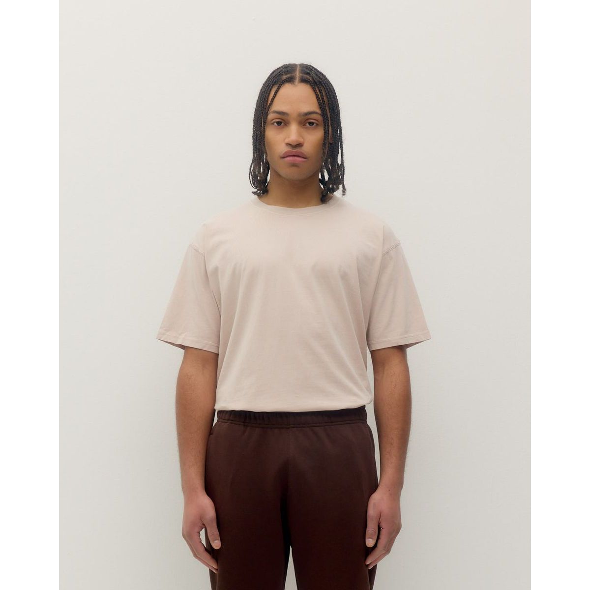 Model wearing Kuwalla Vintage Tee in soft beige, relaxed fit, paired with brown pants.
