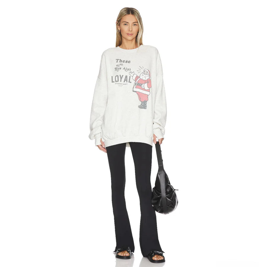 Laundry Room Ain't Crew white sweatshirt with Santa graphic and These hoes ain't loyal text, black flare pants.