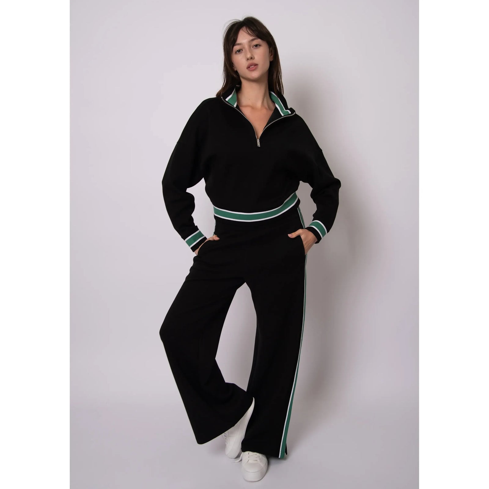 Model in black soft-knit half-zip with green/white stripe trim at collar, cuffs, hem; with stripe-trim pants.