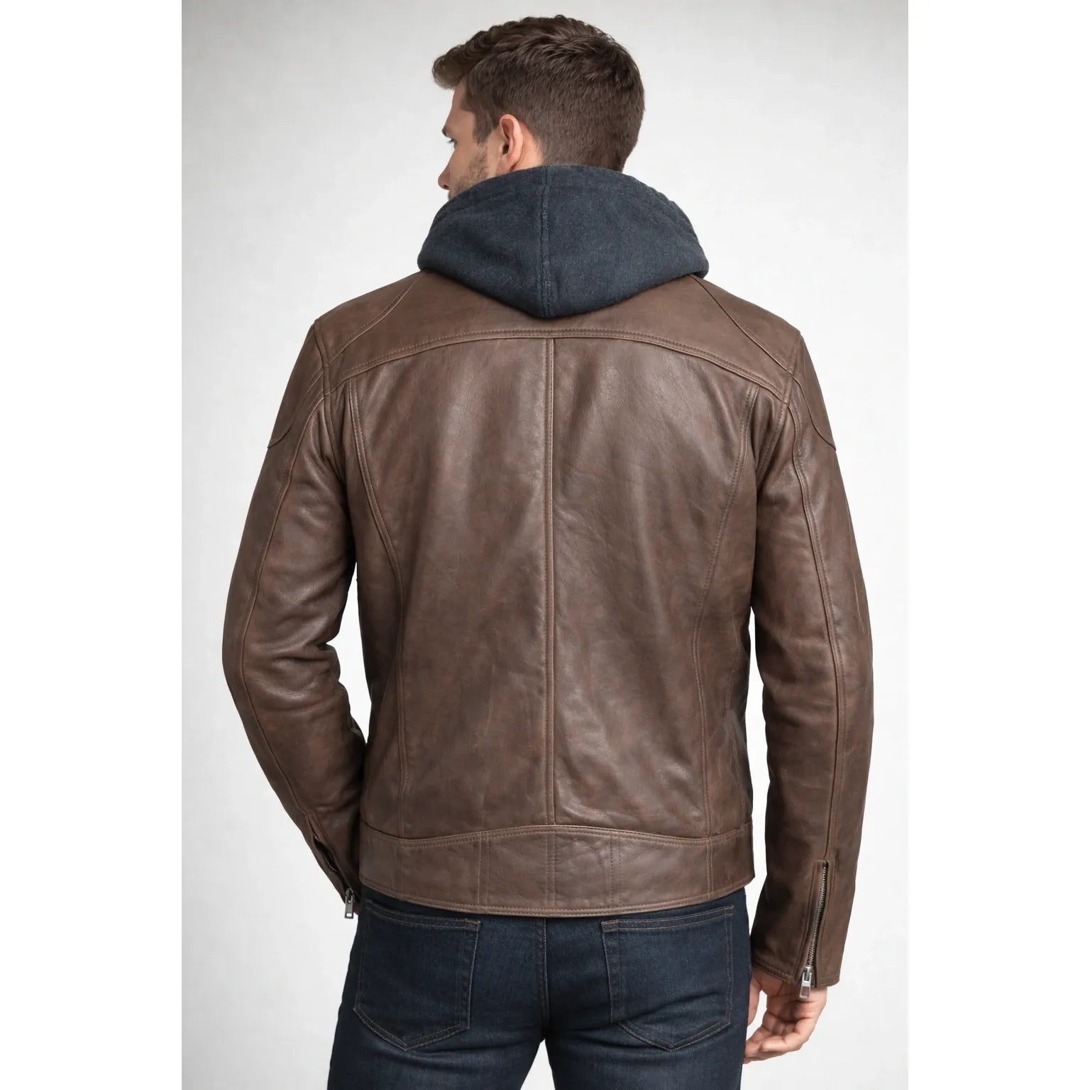 Back view of Mauritius Biko UF Jacket in brown vegetable-tanned lambskin, worn over a gray hooded layer.