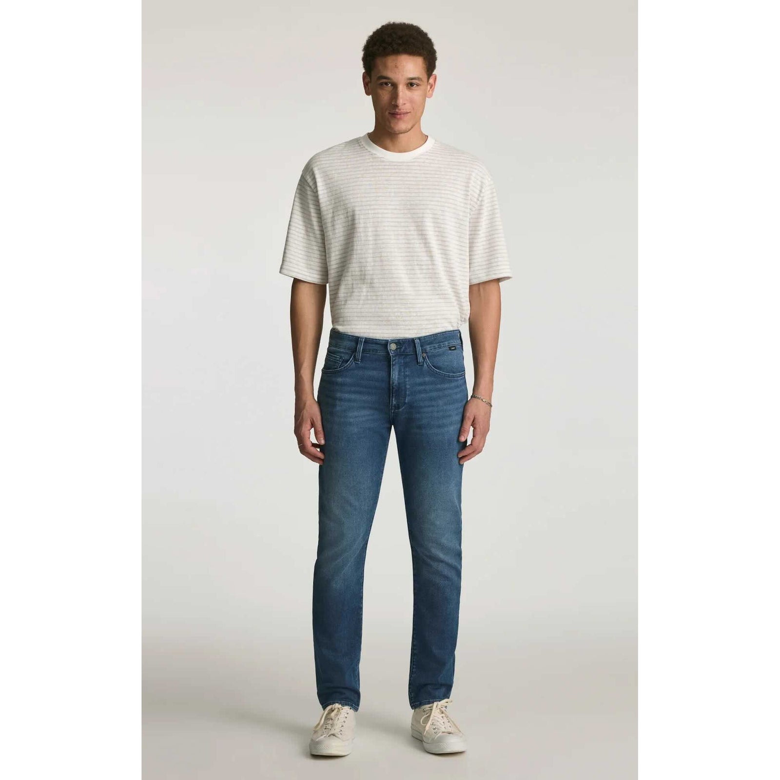 Mavi Jake Mid Explorer Denim jeans on male model; medium blue, regular rise, slim through hip and thigh.