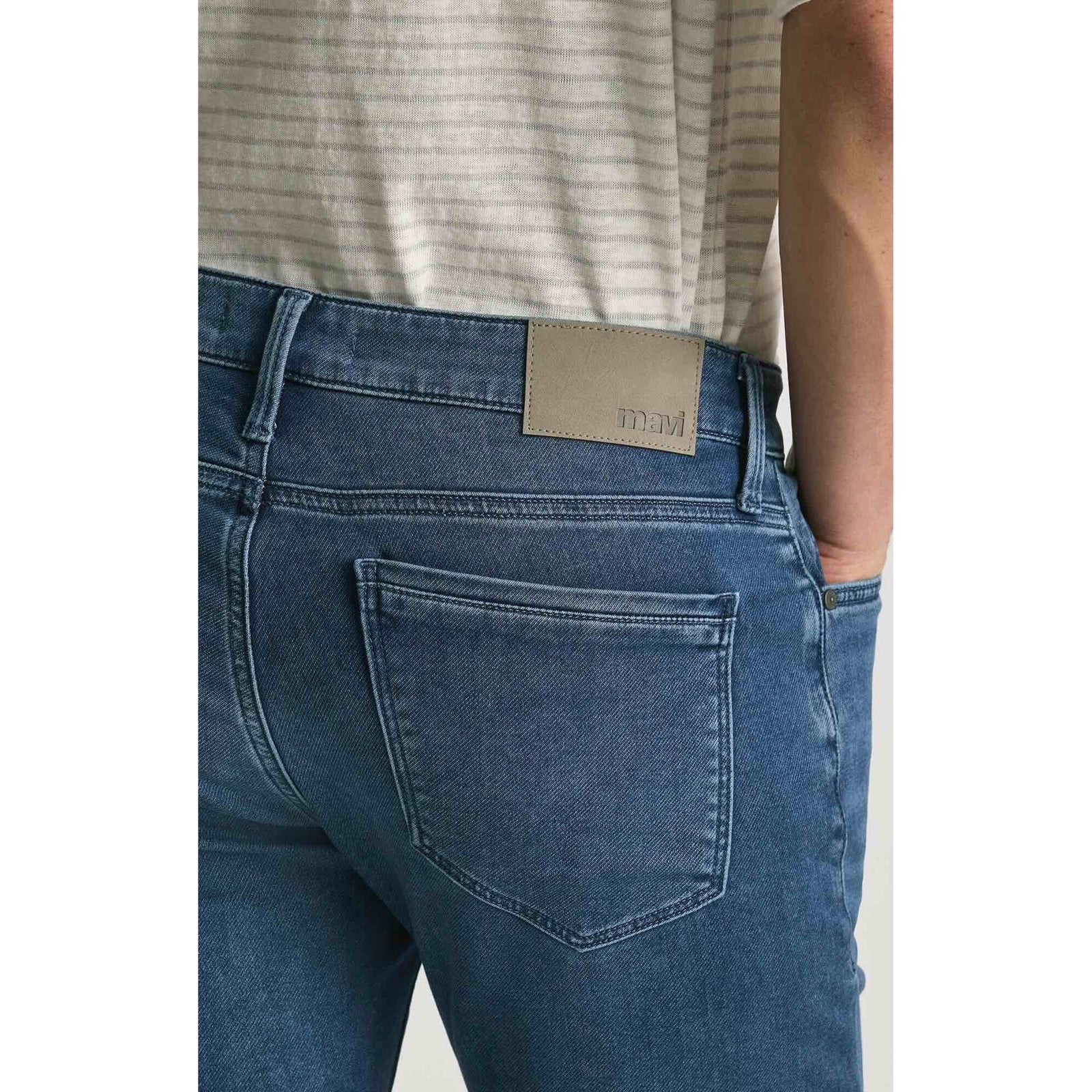 Mavi Jake Mid Explorer Denim jeans, back view in medium blue wash with tan leather waistband patch.