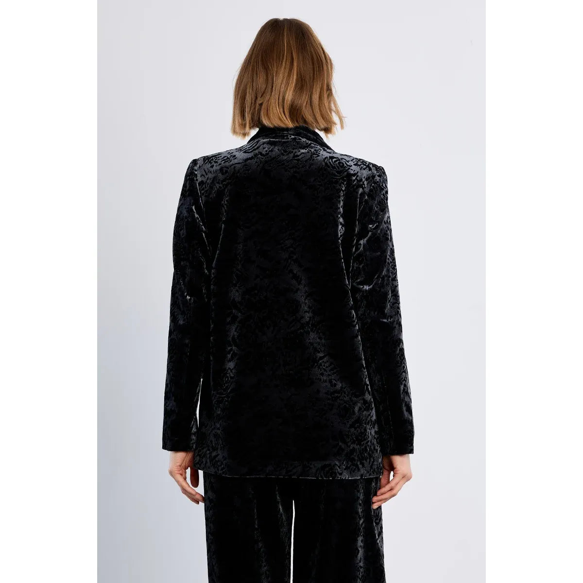 Back view of black floral velvet blazer with straight fit and full lining. Soft texture perfect for dressed-up casual or holiday wear with pants.
