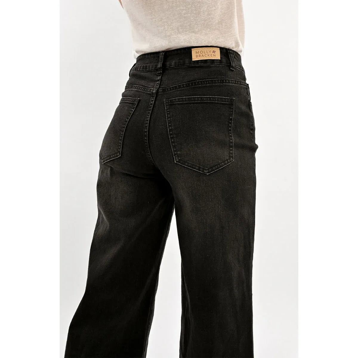 Molly Bracken Jamie wide-leg black denim jeans, back view with leather logo patch and rear pockets.
