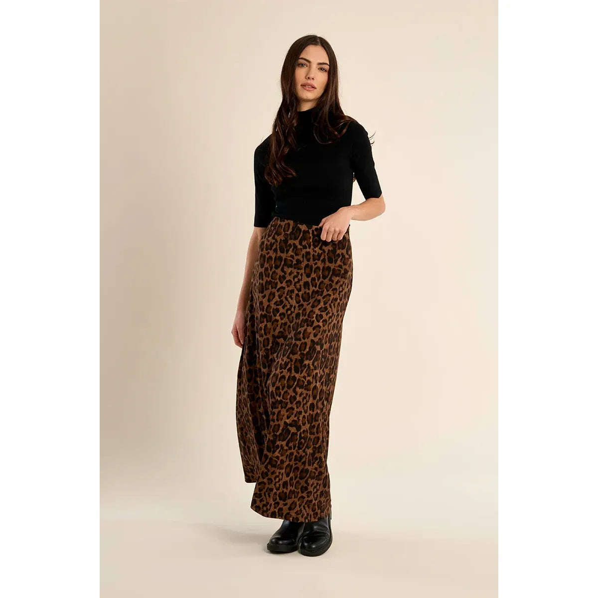 High-waisted leopard print maxi skirt with elastic waistband and straight fit, styled with black top and boots.