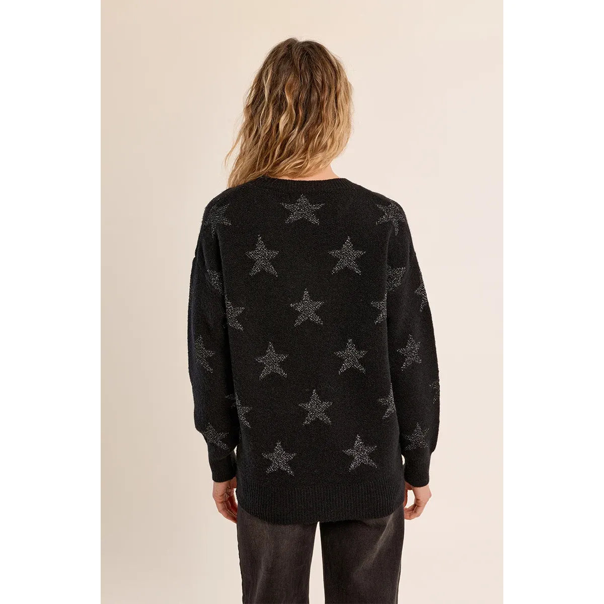 Back view of a black glittery star sweater with an iridescent pattern, round neckline, and relaxed straight fit.