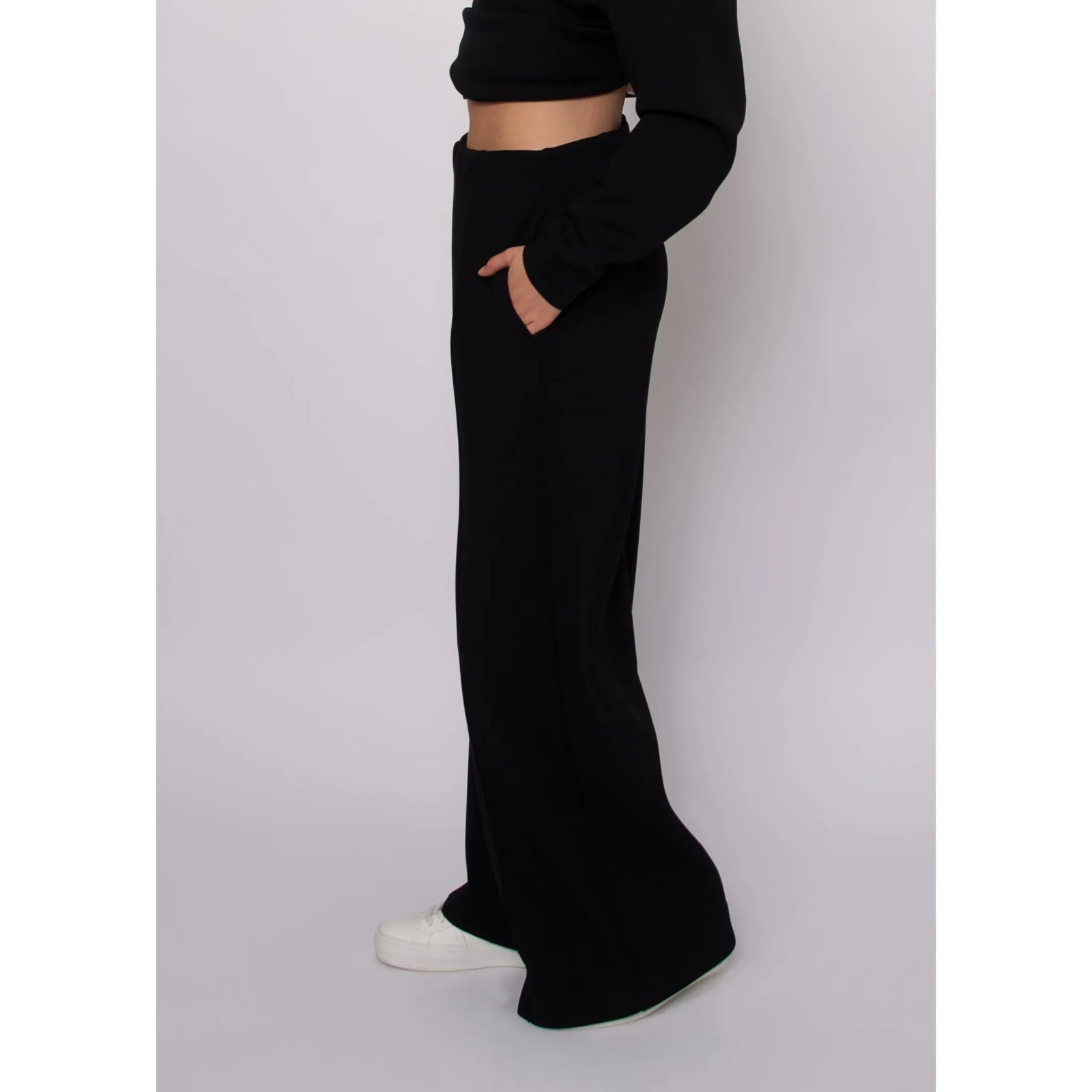 Black high-waisted soft knit pull-on pants with self-tie waist, featuring a relaxed ankle-length drape and side pocket.