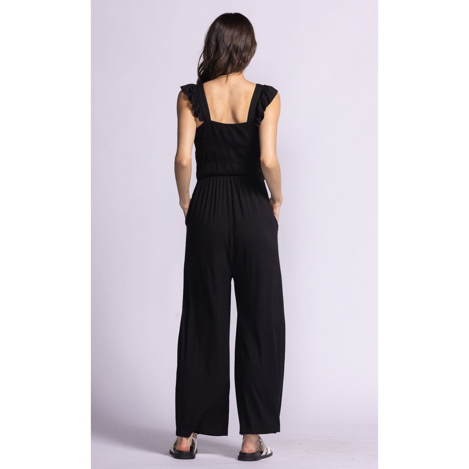 Back view of the Pink Martini Mav Jumper featuring a smocked bodice and convenient side pockets for casual style.