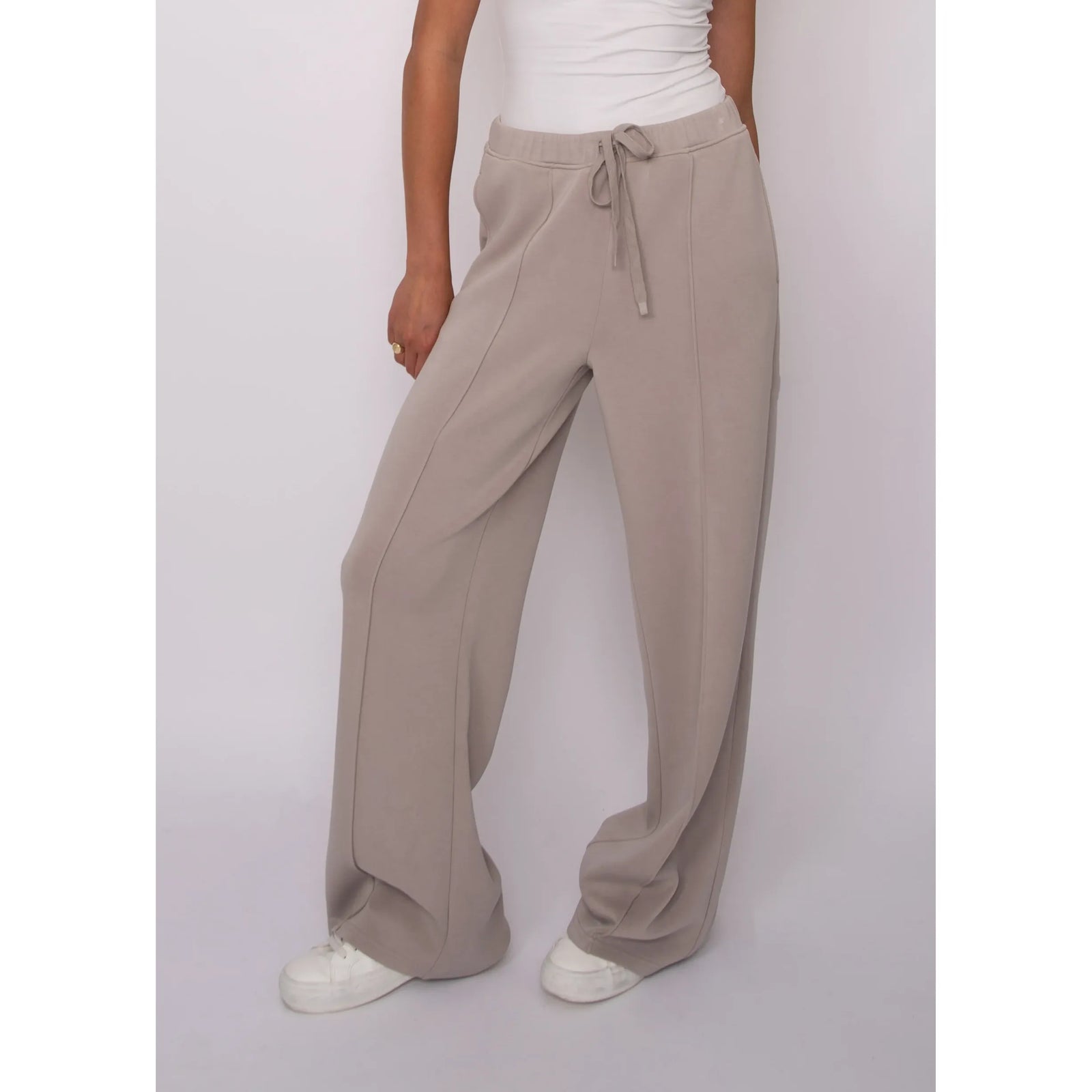 Soft beige knit pull-on drawstring pants featuring an adjustable waistband and relaxed wide-leg fit for effortless comfort.