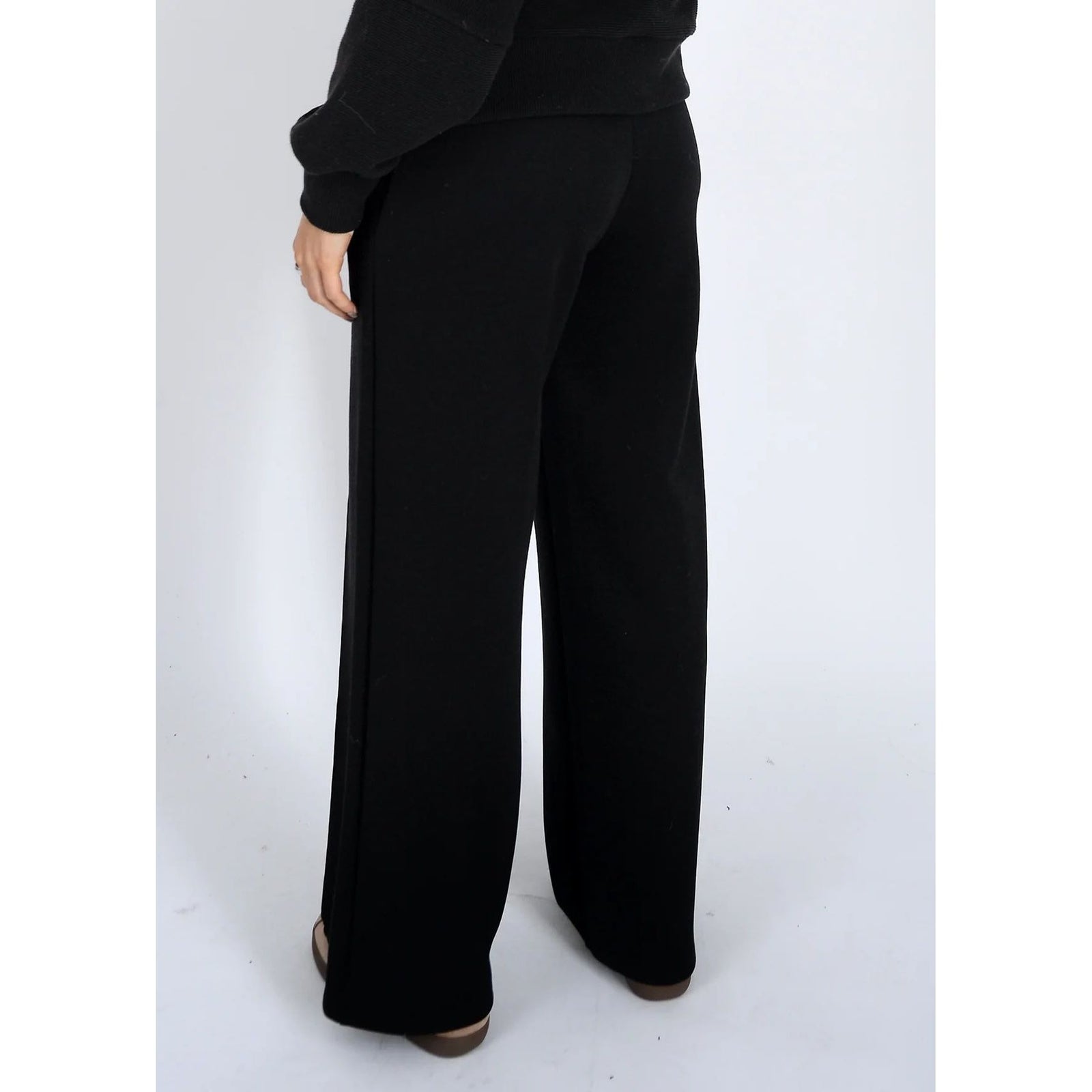 Back view of black soft knit pull-on drawstring pants featuring a wide-leg silhouette and adjustable waist for effortless comfort and style.