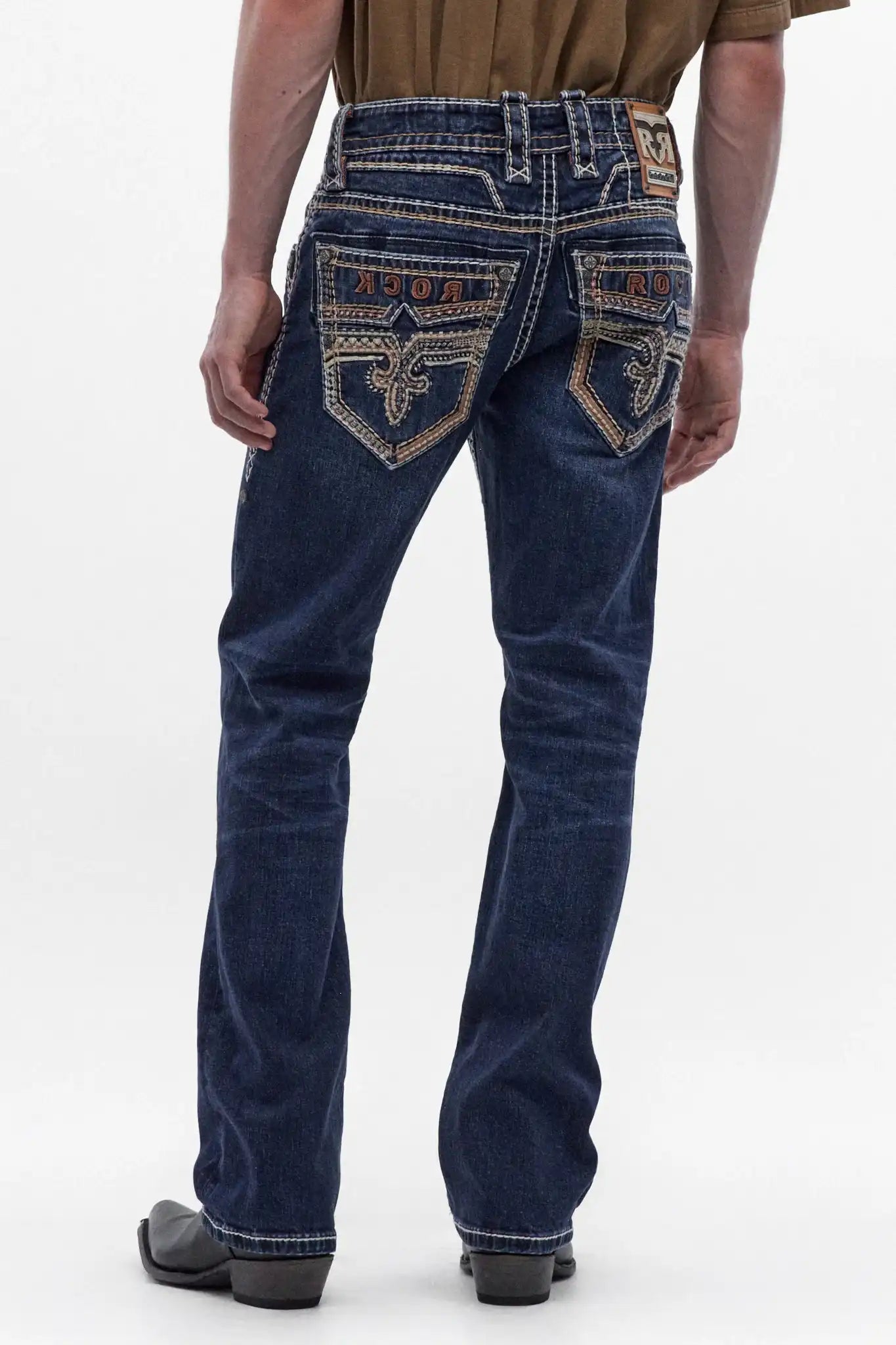 Men's dark blue bootcut jeans featuring ornate fleur-de-lis embroidery on back pockets and detailed contrast stitching.