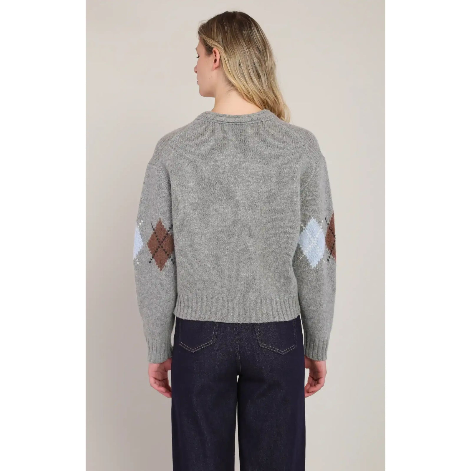 Back view of a grey V-neck argyle sweater featuring diamond patterns in brown and light blue on the sleeves.