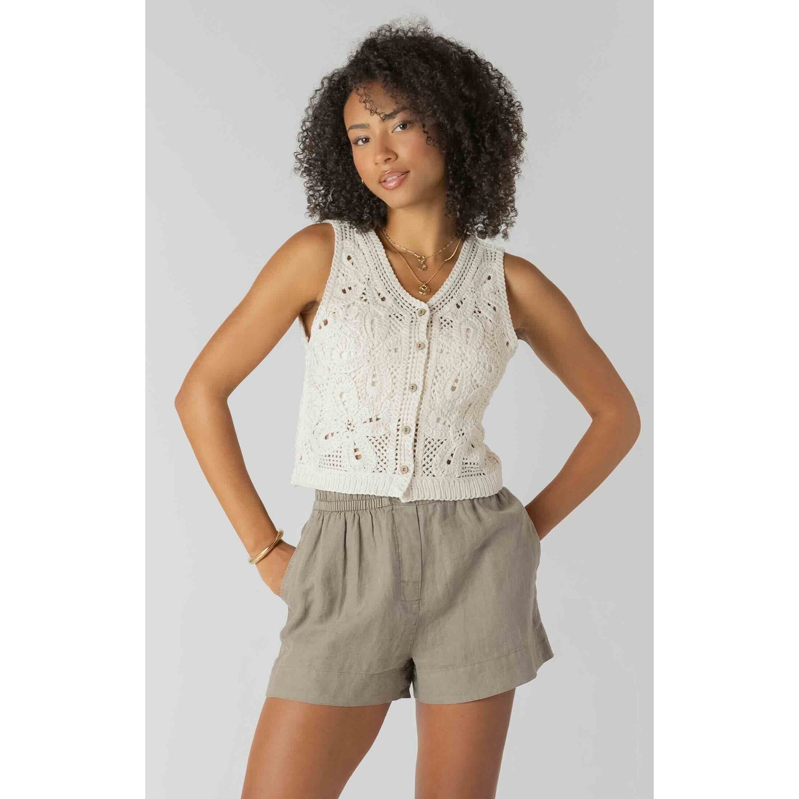 Room 34 crochet buttoned vest on model, cream knit with floral crochet pattern and button front.